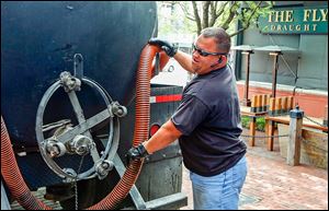 Clay Carrillo-Miranda pumps used grease into a tanker in Fort Worth. To thwart thieves, he stakes out the restaurants that contract with his employer, Haltom City’s Best Grease Service, because, he says, thieves can strike fast.