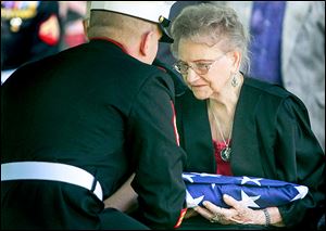 Dorothy Sobczak, Cpl. Harold Reed’s wife at the time of his death in 1950, is presented with a folded American flag at Mr. Reed’s funeral service at Ottawa Hills Memorial Park in Toledo on Saturday.