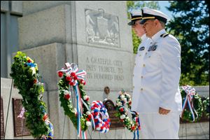 Navy CWO 4 Michael Joseph, left, and Navy Lt. Cmdr. Vidal Valentin stand at attention after placing the wreath during the annual Memorial Day service at the Civic Center Mall. 