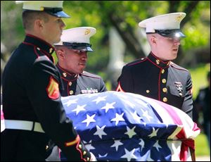 Marines Cpl. Kenneth Arp, left, Sgt. Marshall Grayson, center, and PFC. Austin Adams, right, carry the flag-covered casket of Cpl. Harold W. Reed to his final resting place.