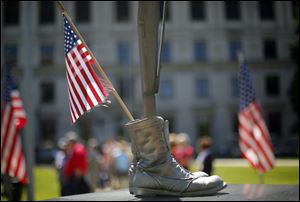 A flag in placed in the boots on the memorial at the Civic Center Mall.