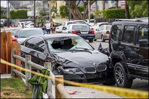 A black BMW sedan crashed near a house in Isla Vista, Calif., apparently driven by a drive-by shooter Friday.