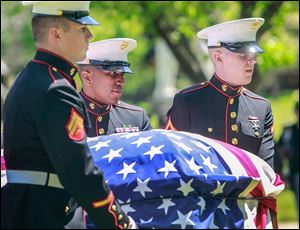 Marines Cpl. Kenneth Arp, left, Sgt. Marshall Grayson, center, and Pfc. Austin Adams carry the casket of Cpl. Harold Reed to his final resting place in Ottawa Hills Memorial Park on Saturday.