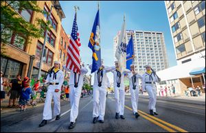 U.S. Navy members march down North Summit Street while holding the colors during the annual Memorial Day parade in Toledo.