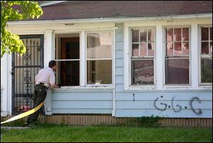 Authorities look into 2143 Joffre Avenue where a G.G.C. (or Geer Gang Crip) tag is located on the side of the house. 
