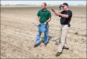 Eric Richer, Ohio State Extension educator, left, talks to Metamora farmer Keith Truckor on his 65 acres of corn crop, where he took nitrogen samples.