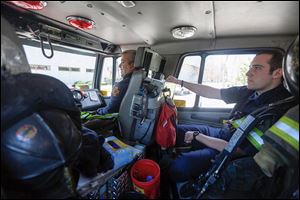 Tony Salazar, left, and Barrett Dorner, from Toledo Fire Station 7, talk about their medical run on  their way back to the station.