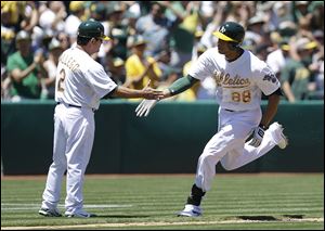 Oakland Athletics' Kyle Blanks, right, is congratulated by third base coach Mike Gallego (2) after hitting a home run off Detroit Tigers' Drew Smyly  in the second inning.