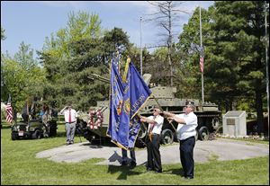 Dave McVey of American Legion Joseph W. Diehn Post 468 in Sylvania, left, salutes during the posting of the  colors. The color guard personnel are John E. Schuster, behind the flags, and John A. Nye, both members of Veterans of Foreign Wars Remagen Bridge Post 3717 in Sylvania, and Joe Navarre, right, of American Legion Post 468. 