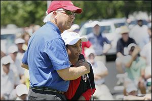 Inverness Club board member Jerry Lemieux  holds the microphone for 11-year-old Mihir Joshi of Sylvania. 