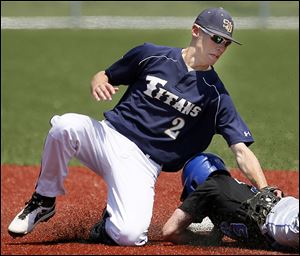 St. John’s second baseman Ethan Kirkman tags out  Findlay's Austin Cameron in the TRAC semifinal game at Mercy Field in Toledo. Kirkman scored the first run of the 9-1 victory.