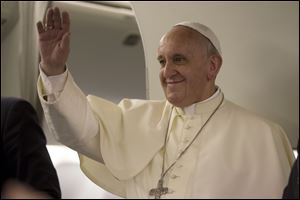 Pope Francis waves to journalists as he arrives for a press conference he held aboard the papal flight on his way back to Rome at the end of a three day trip to the Midle East, Monday, May 26, 2014 (AP Photo/Andrew Medichini, Pool)