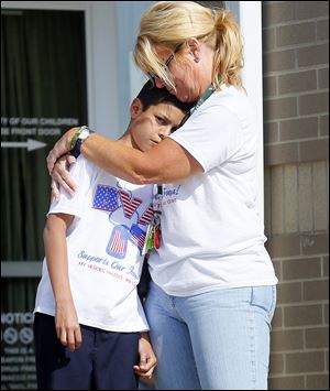 Bennett Venture Academy third-grade student Alex Lazaney-Molina is comforted by organizer Dawn Taylor.