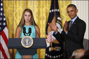 President Barack Obama applauds Victoria Bellucci, a 2014 graduate of Huntingtown High Shool in Huntingtown, Md., who suffered five concussions playing soccer.