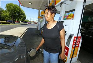 Danyale Brown fills a vehicle at the Shell station at Secor Road and Monroe Street on Friday.