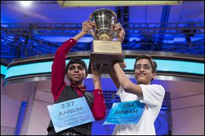 Ansun Sujoe, 13, of Fort Worth, Texas, left, and Sriram Hathwar, 14, of Painted Post, N.Y., raise the championship trophy after being named co-champions of the National Spelling Bee, on Thursday in Oxon Hill, Md.