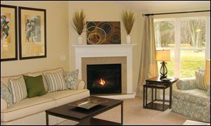 A vaulted ceiling and a gas fireplace with a granite surround make this great room an inviting space. 