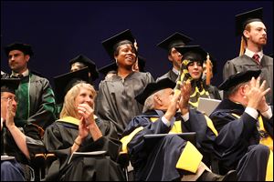 Master of public health graduates including Keva Miller, center, stand to be recognized during commencement for 255 graduates on Friday afternoon at the Stranahan Theater in South Toledo.