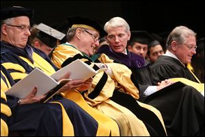 LEFT: Dr. Lloyd Jacobs, president of the University of Toledo,  left, talks with Sen. Rob Portman (R., Ohio) during commencement at the Stranahan Theater.