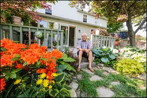 Kevin Kwiatkowski enjoys his garden from his back porch. The Oregon resident says he enjoys tending to his flowers and planting varieties of agave. His garden is to be part of the garden tour.