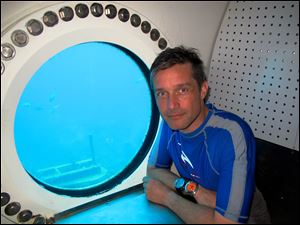 This 2012 photo provided by Mission 31,  Fabien Cousteau sits in the entrance to Aquarius Reef Base in the Florida Keys National Marine Sanctuary. Beginning Sunday, June 1, 2014, the filmmaker and Jacques Cousteau’s grandson plans to spend 31 days living underwater at the lab, making a documentary and leading a five-person crew on science experiments.  (AP Photo/Courtesy of Mission 31) 