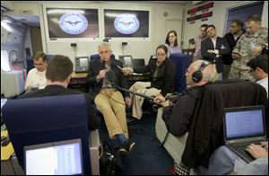 U.S. Defense Secretary Chuck Hagel, center, is seen aboard a U.S. Military Aircraft before speaking to members of the media during his flight.