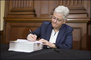 Environmental Protection Agency Administrator Gina McCarthy signs new emission guidelines during an announcement of a plan to cut carbon dioxide emissions from power plants by 30 percent by 2030, today, at EPA headquarters in Washington.