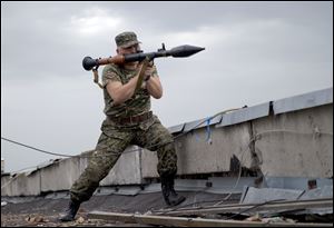 A pro-Russian rebel prepares to fire a rocket propelled grenade during clashes as they attack a border guard base held by Ukrainian troops on the outskirts of Luhansk, eastern Ukraine, today.