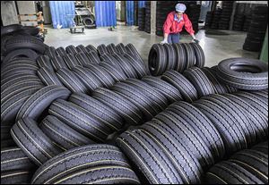A worker moves tires at a tire factory in Hangzhou, in east China’s Zhejiang province. Chinese-made tires meet U.S. safety standards, but can cost significantly less than from the major brands.