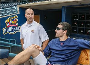 New Mud Hens trainer Chris McDonald, left, chats with pitcher Robbie Ray in the dugout.