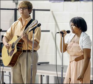 Faith Dickerson, 15, accompanied by Ross Thompson of the Toledo School for the Arts, sings ‘School Is A Good Thing,’ an original composition she wrote, during her class graduation on Tuesday.