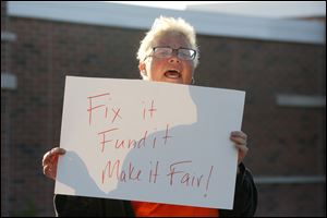Shannon Conway, a fix line employee of TARTA, holds a sign during an Amalgamated Transit Union protest and rally outside of the Toledo Area Regional Paratransit Service headquarters on Knapp Street. 