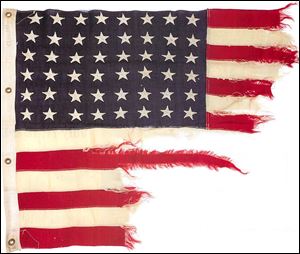 A tattered 48-star American flag that flew aboard the U.S.-built LST 493 on D-Day.