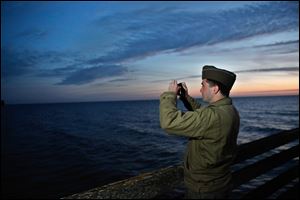 A military enthusiast takes a snapshot of Omaha Beach, western France.