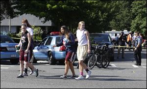 Students help each other as they walk away from the scene of a shooting Thursday.