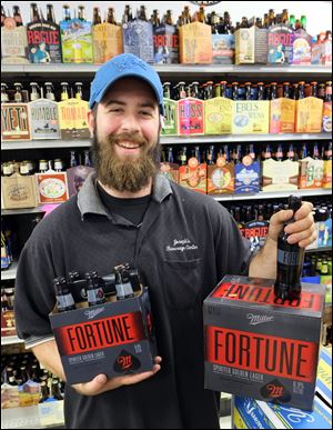Joe Fisher of Joseph’s Beverage Center, shows Miller Fortune’s bottling.  MillerCoors says the packaging has prompted consumers to say  ‘‍no other beer looks like Miller Fortune.’