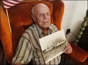 Walter Schuhmacher holds a photo of the USS Omaha, the ship on which he served in the Navy during World War II.