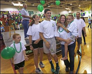 The Gandee family, from left, Kellen, Kerragan, Hunter, mom Danielle carrying Braden, and dad Sam, welcome more than 300 supporters at Bedford Junior High School on Saturday as Hunter, 14, begins his journey to carry his 7-year-old brother, Braden, on his back to Ann Arbor.