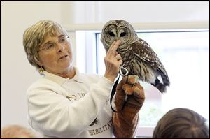 Mona Rutger, shown working with a barred owl, runs ‘‍Back to the Wild,’ a nature hospital for rare and exotic creatures that have been injured.