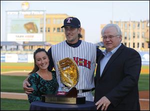 Pat O‘Conner, right, president and CEO of Minor League Baseball, presents Toledo Mud Hens player Jordan Lennerton with a Gold Glove award in Toledo this spring. At left is Mr. Lennerton’s fiancee, Ashley Swistchew.