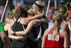 The Perrysburg girls 3200 relay team hugs in celebration of their record-setting run in Friday’s Division I state championship race.