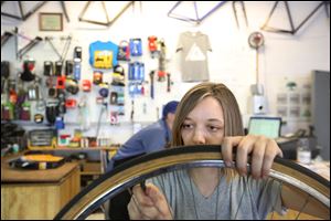 Shop assistant Alanna Cromley replaces a tube while working on restoring an old bike.