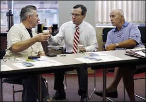 Brian Castro, ombudsman for the U.S. Small Business Administration, center, talks with John Insco of Toledo, left, and Ray Zammit of Oregon on Thursday at the Toledo Regional Chamber of Commerce offices in Toledo. Mr. Castro was in town to advise small business owners on how to get help.