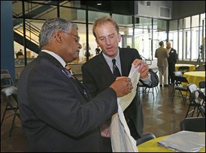 Nagi G. Naganathan, UT professor and dean of the engineering college, left, looks at packing material shown by Sean Hadley, co-owner of H&H Specialities. 