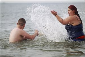 Bobby Moser turns his head as Cearra Garner splashes him at Maumee Bay State Park on Thursday. Lake Erie is the warmest of the Great Lakes, partly because it is the shallowest and most southerly.