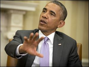 President Obama answers questions on violence in Iraq during his meeting with Australian Prime Minister Tony Abbott, today, in the Oval Office of the White House in Washington.