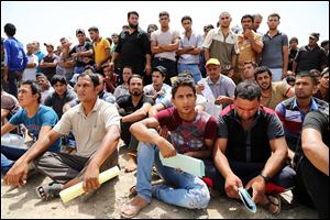 Iraqi men gather outside of the main army recruiting center to volunteer for military service in Baghdad, Iraq, Thursday after authorities urged Iraqis to help battle insurgents.  