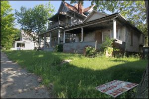 An abandoned home, right, sits on South Avenue in South Toledo. Readers and city officials agree it’s time for action.