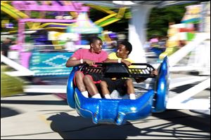 Jayrod Witcher, 13, left, looks at Jajuan Brown, 13, right, in excitement as they ride the scrambler ride during the Strawberry Festival in Holland Friday.