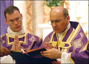 In this photo provided by The Catholic Sun, the Rev. Kenneth Walker, left, and the Rev. Joseph Terra perform a Mass in Phoenix. Walker was killed and Terra was critically injured during a robbery attempt at Mother of Mercy Mission church last Wednesday.